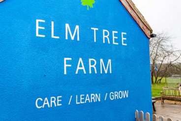 Elm Tree Farm sign with the words: Care, Learn, Grow